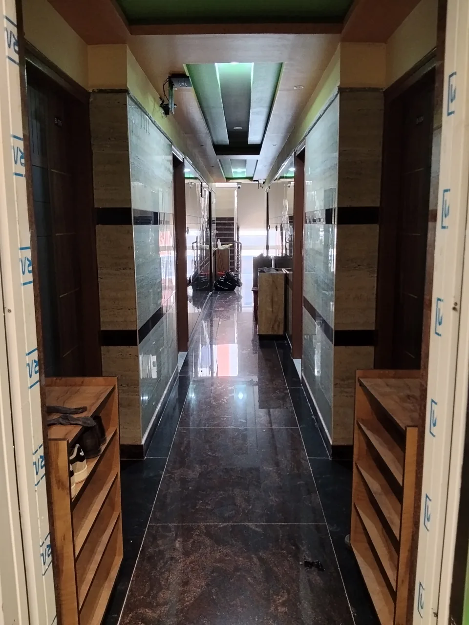 Tiled corridor with room doors on both sides.
