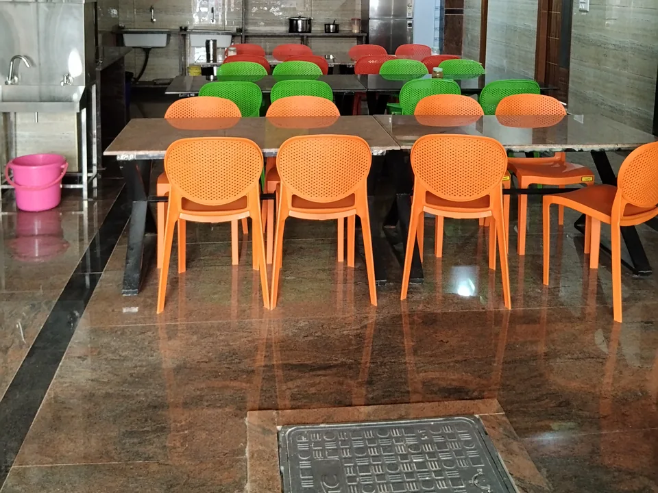 Orange and green chairs around tables in the dining space.