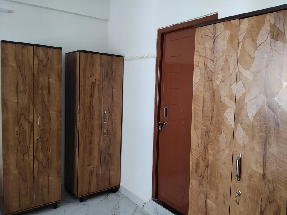 Wooden wardrobes beside a closed door inside a room.